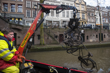 909454 Afbeelding van het opdreggen van fietswrakken uit de Oudegracht te Utrecht door de Gemeentelijke Reinigings- en ...